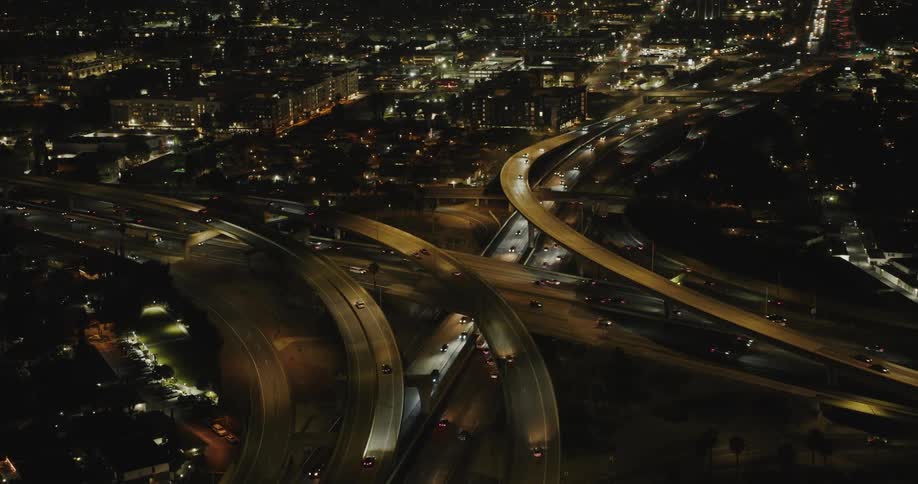 Aerial panorama of an urban city with overpasses and streets with vehicle traffic at night today