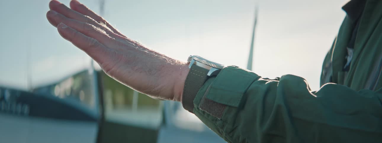 Hand of a man with a watch on his wrist raised his hand up