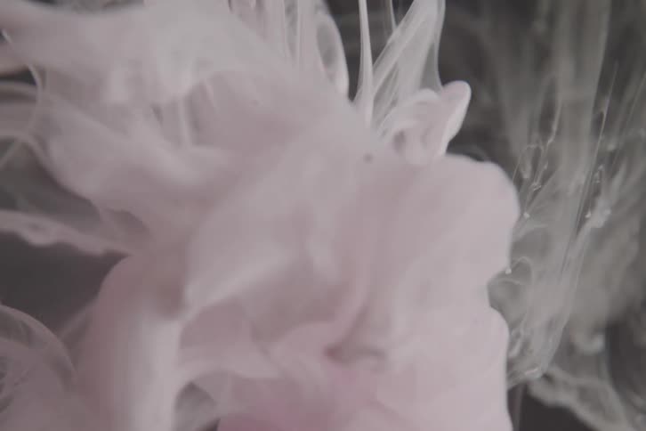 Pink ink clouds floating down in water