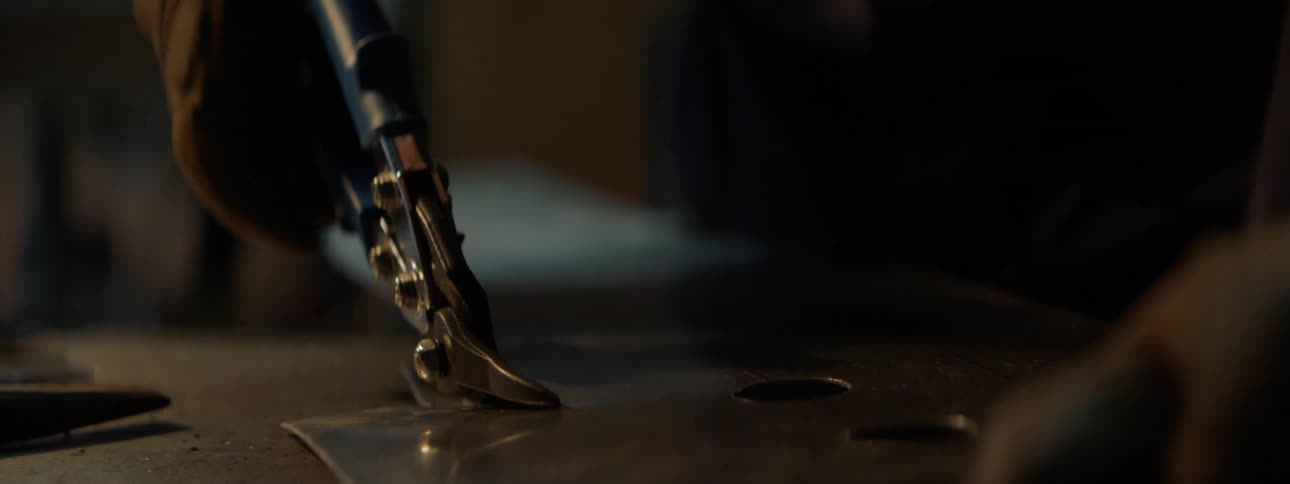 A worker moves a hand tool