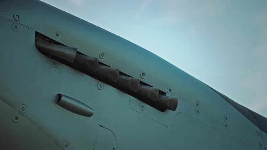 Closeup of the side of a singleengine plane with the propeller turning on a blue sky day