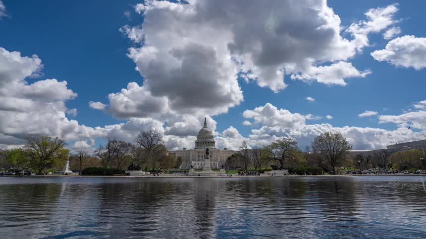 Panorama of the capitol in washington of the united states in front of a lake with a day passing in time lapse