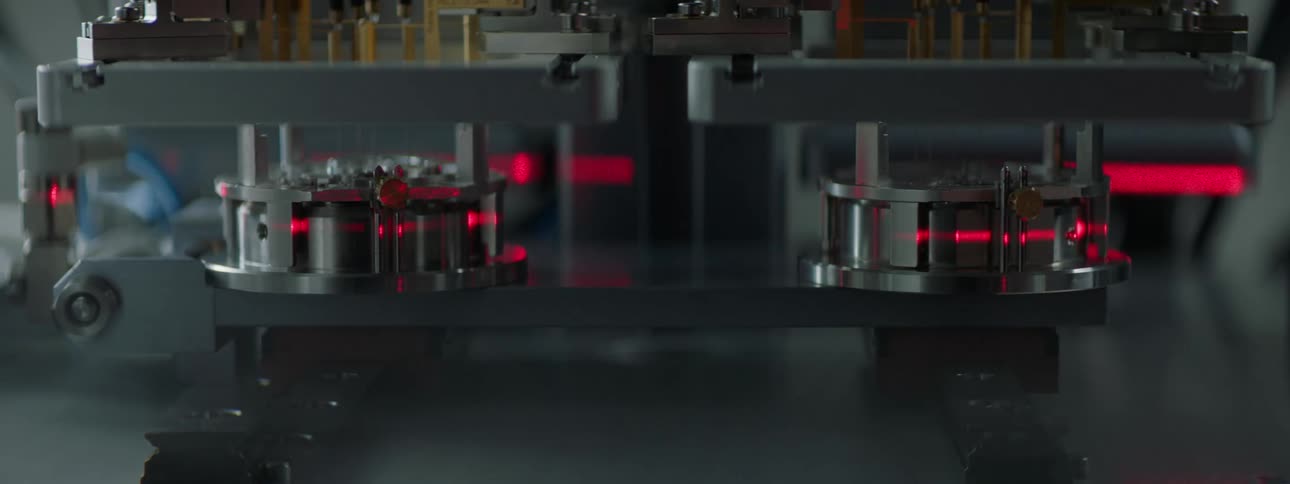 A closeup of a red laser beam measuring metallic pieces
