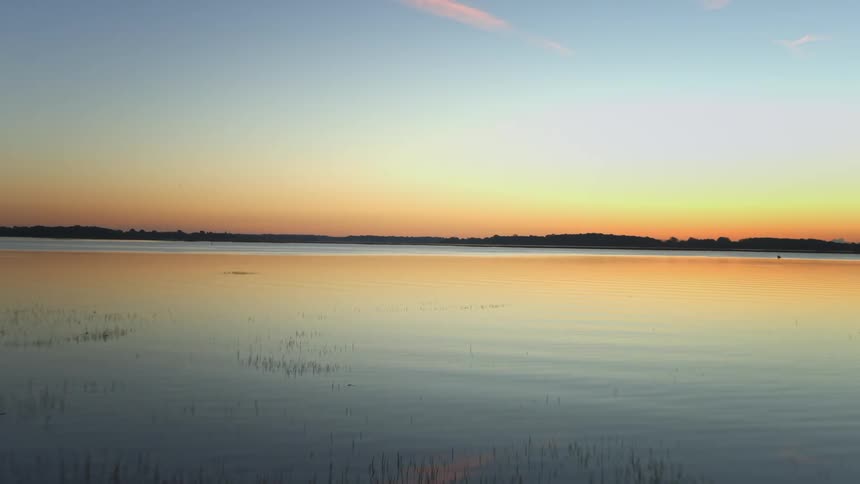 Aerial view of a placid lake at sunset