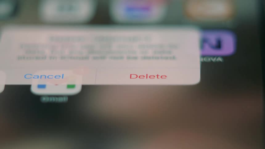 A person taps a phone screen uninstalling an application