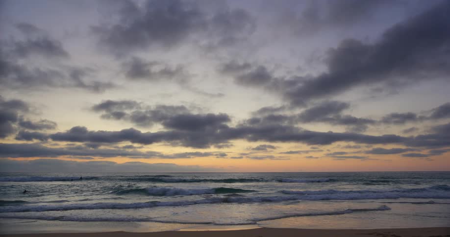 Waves crashing on the shore at sunset