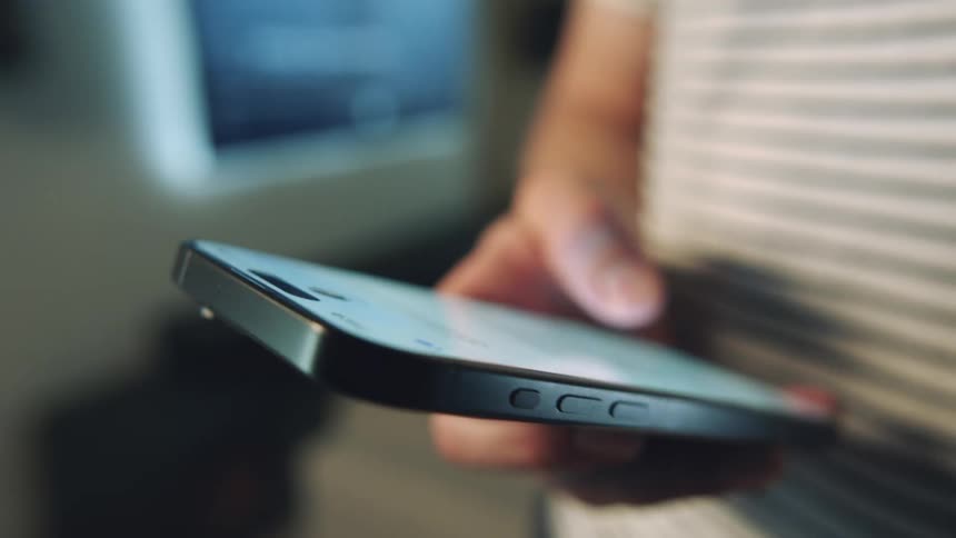 Closeup of a persons hand typing on an iphone