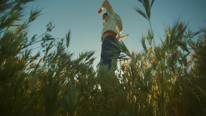 A man spins around while standing in a field