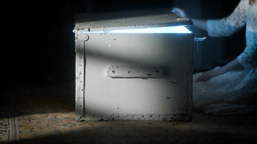 Girl hands open a box and a bright light appears