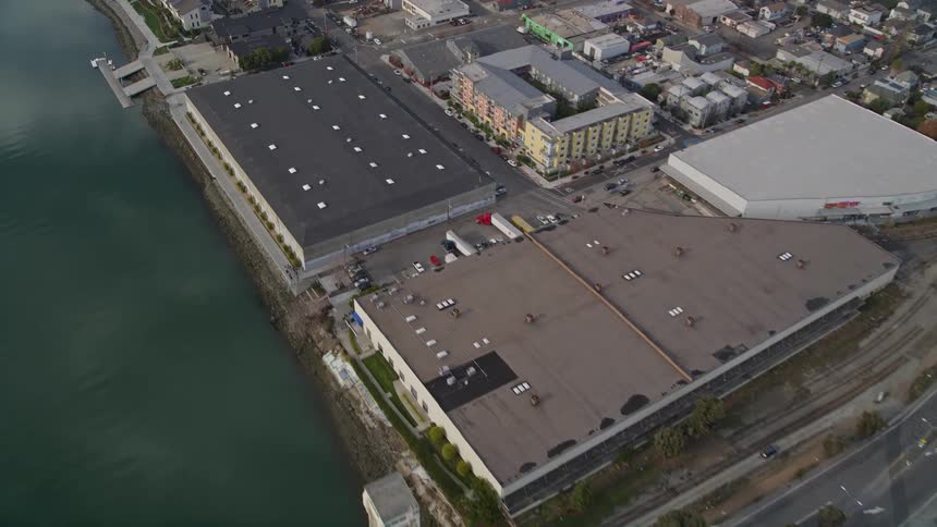 Aerial panorama of a canal at sea dividing a residential city and factory sector