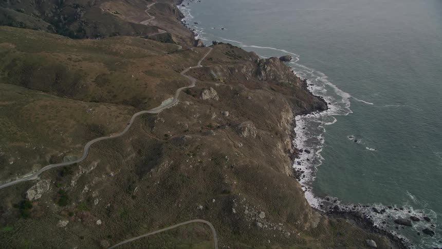 Aerial panorama of an extensive highway with curves in the middle of mountains on the sea coast