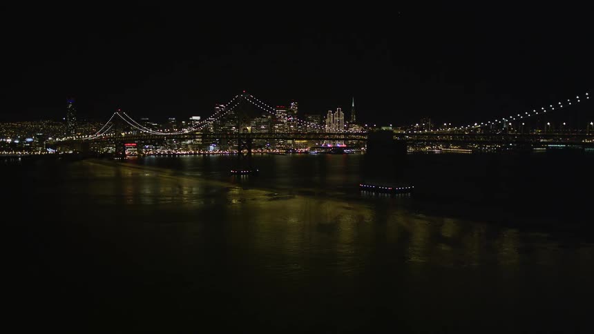 A bridge with lights near a major city