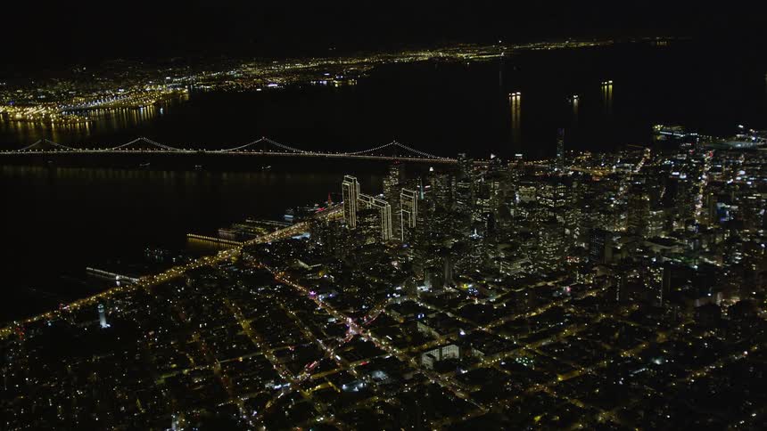 Aerial panorama of a seaside metropolis with a long bridge connecting the cities and a night view