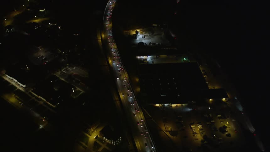 Aerial panorama of an extensive highway with viaducts and vehicle traffic at night
