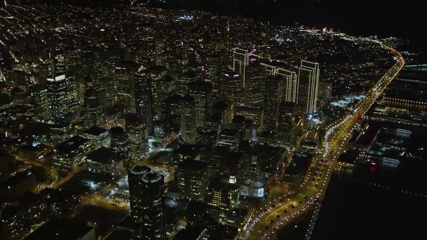 An aerial view of a large city with several tall buildings and many lights are on