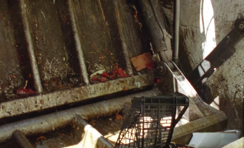 Trash thrown into a truck is crushed