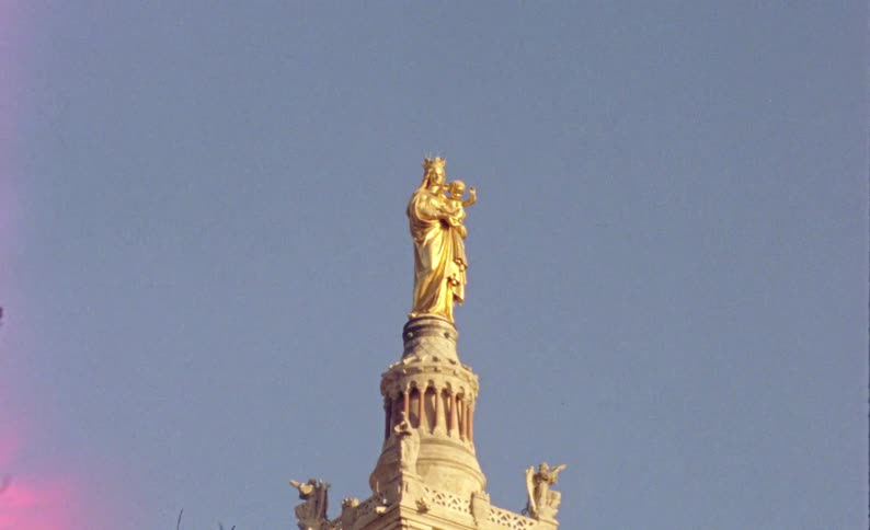 A church with a giant statue near parked cars