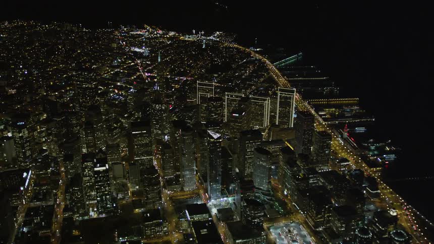 Aerial panorama gave a seaside metropolis view at night with the skyscrapers and modern buildings illuminated
