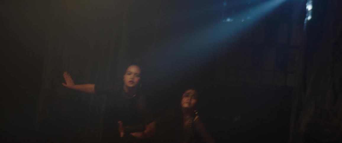Two dancers inside a dimly lit studio dancing a joint choreography