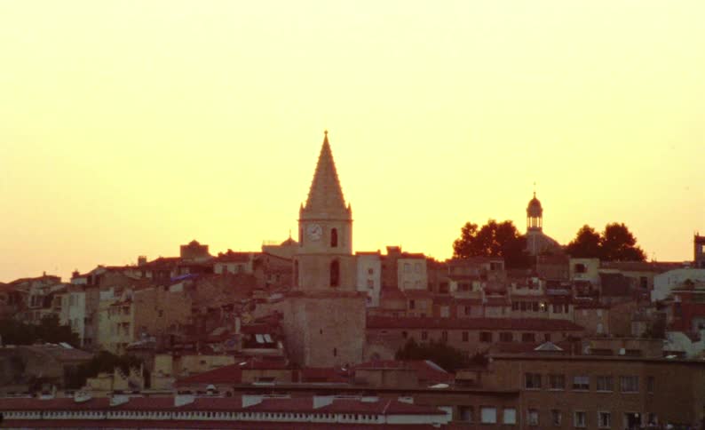 Panorama of a city with buildings and urban houses on hills on a morning with orange sky