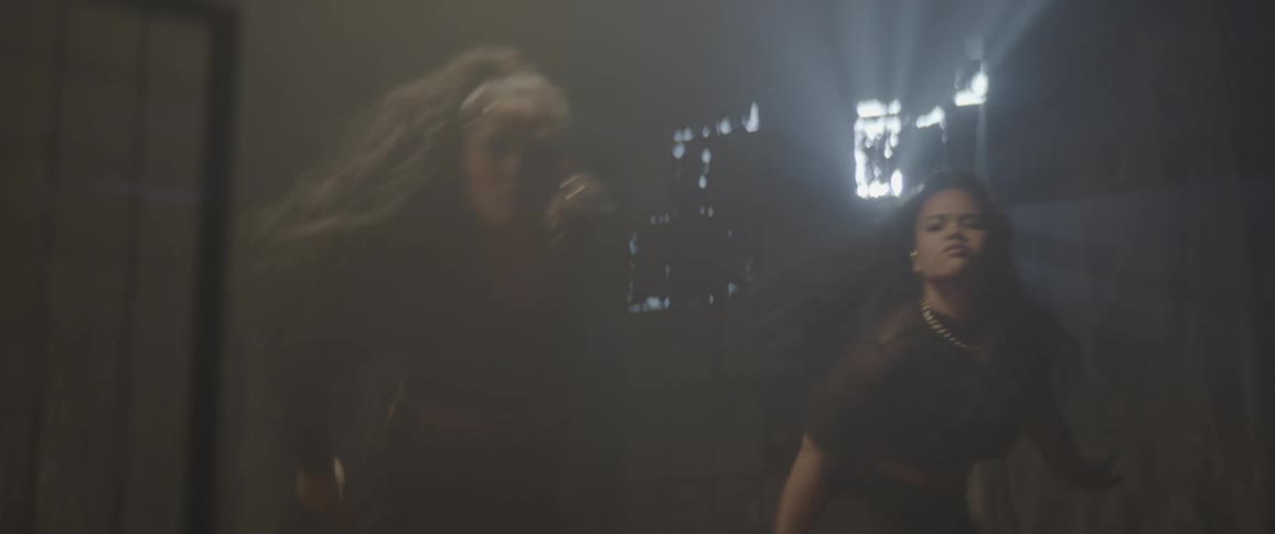 Two young women dancing a choreography indoors