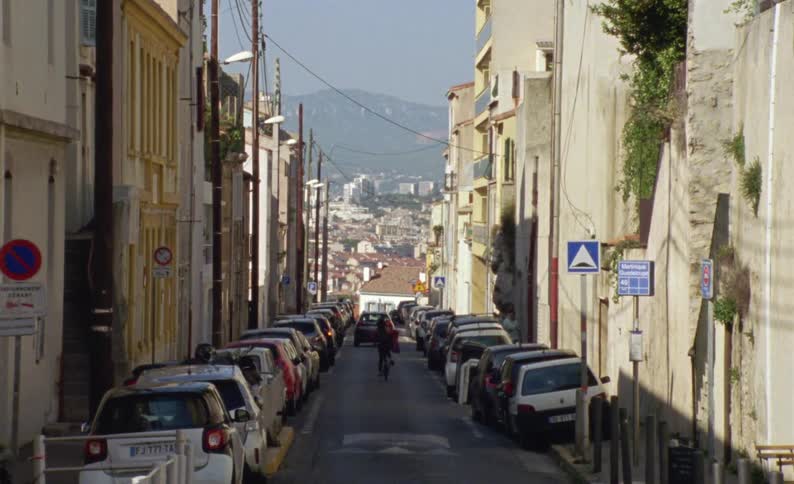 A person is riding their bicycle down the block