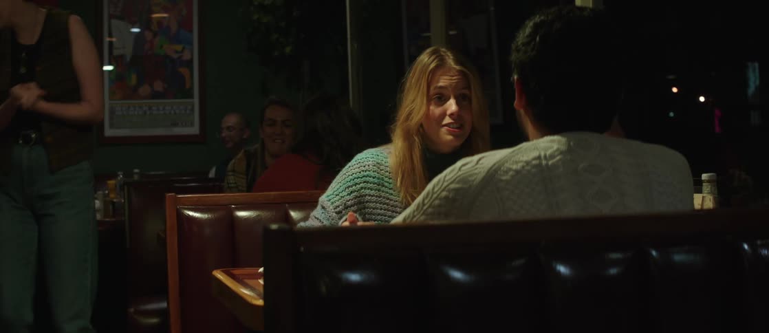 A young couple have dinner at a cozy restaurant at night