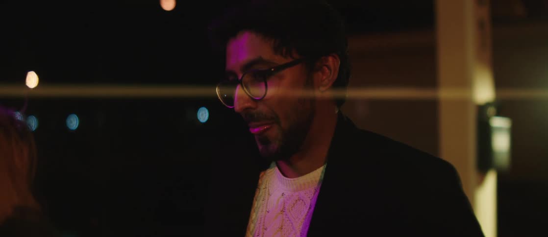 While talking to friend at night man puts on his coat and then they leave