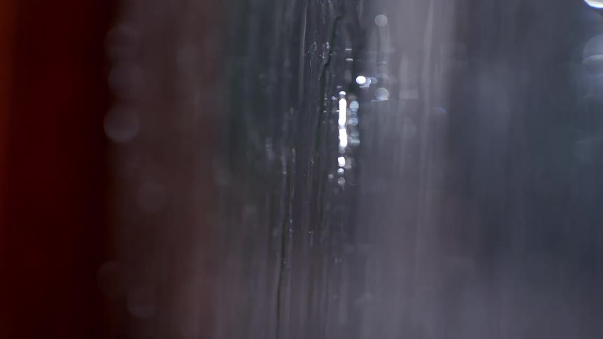 Raindrops running down glass