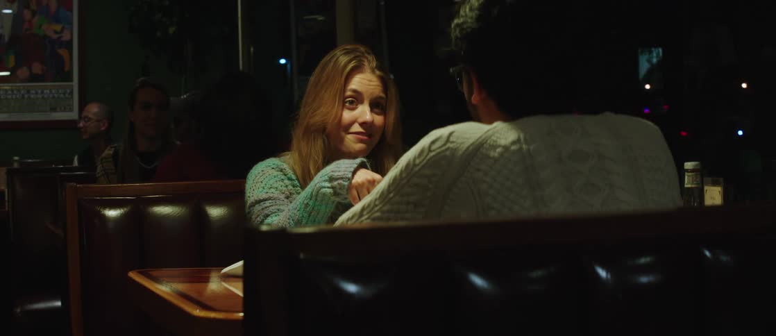 A young couple have dinner at a cozy restaurant at night