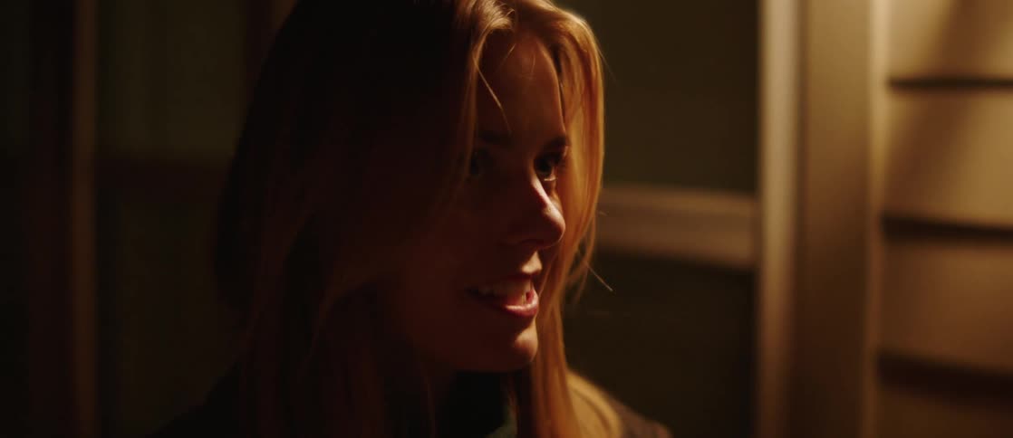 Close up of the face of a young woman in a cozy room at night