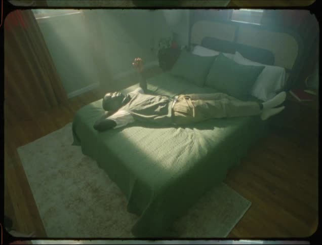 Man lying in bed with sun glare on him