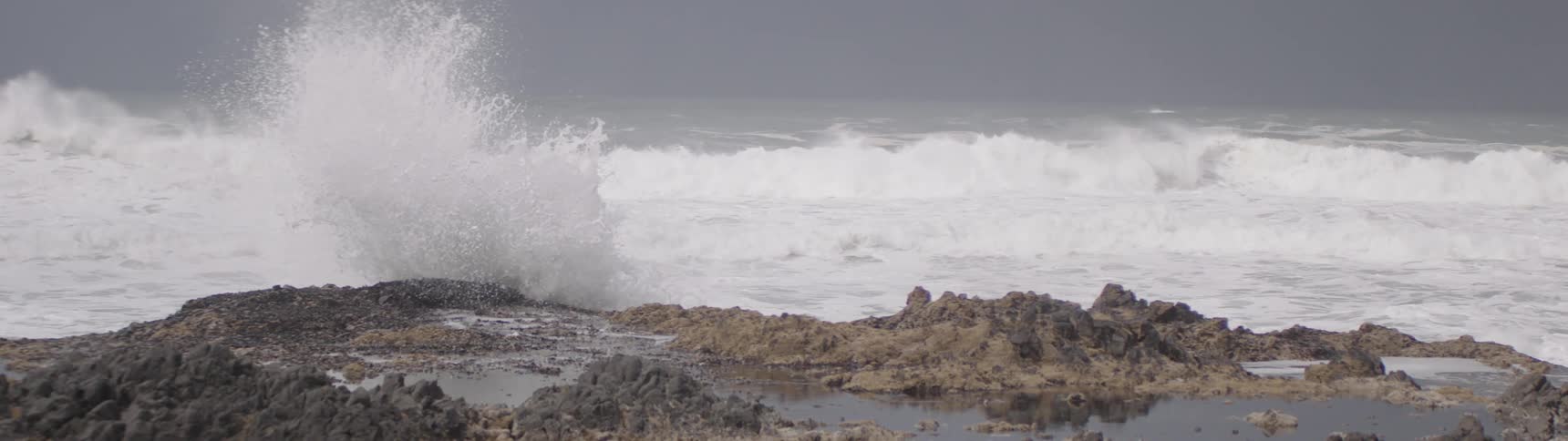 Foamy waves hit a rocky shore