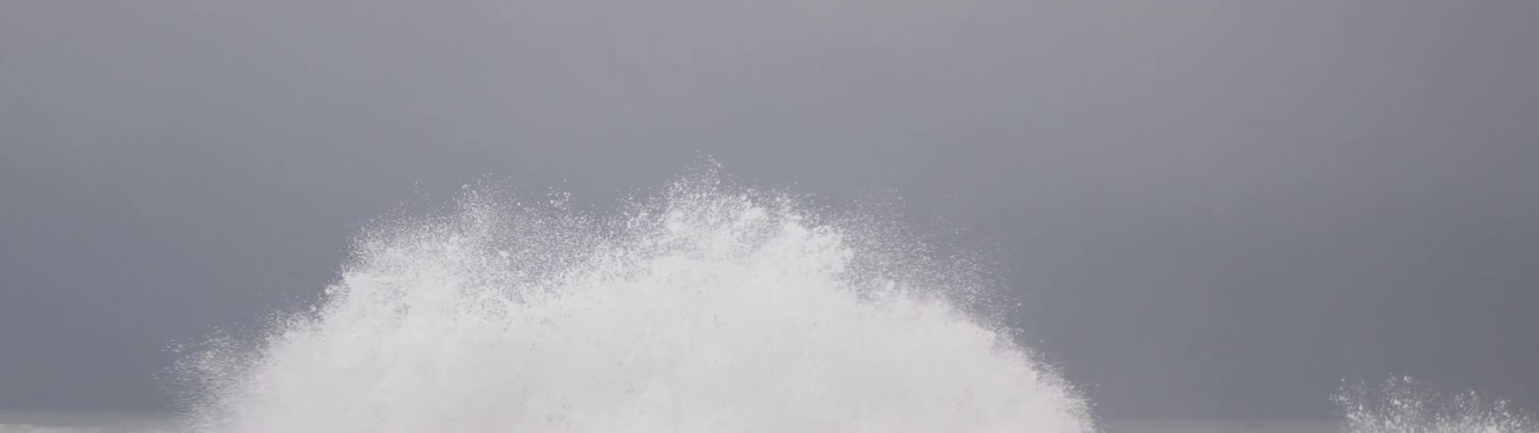 Ocean waves hitting seaside rocks and impacting and exploding