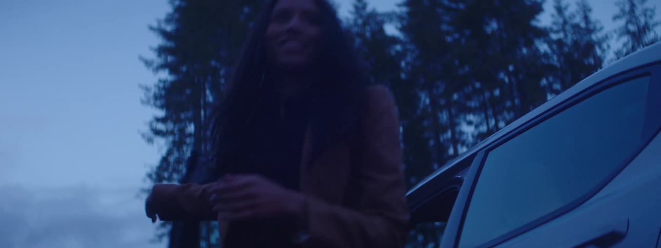 A smiling woman leaves her car