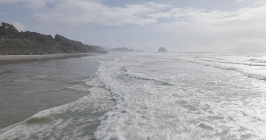 Natural scenery of calm waves on a coastal beach during the day