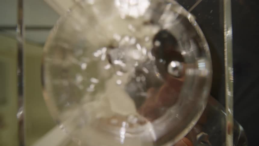 A black man pours water into a glass container