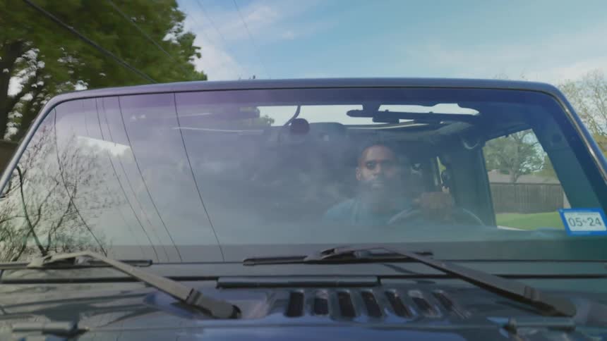 Man driving with his dog next to him in the front seat