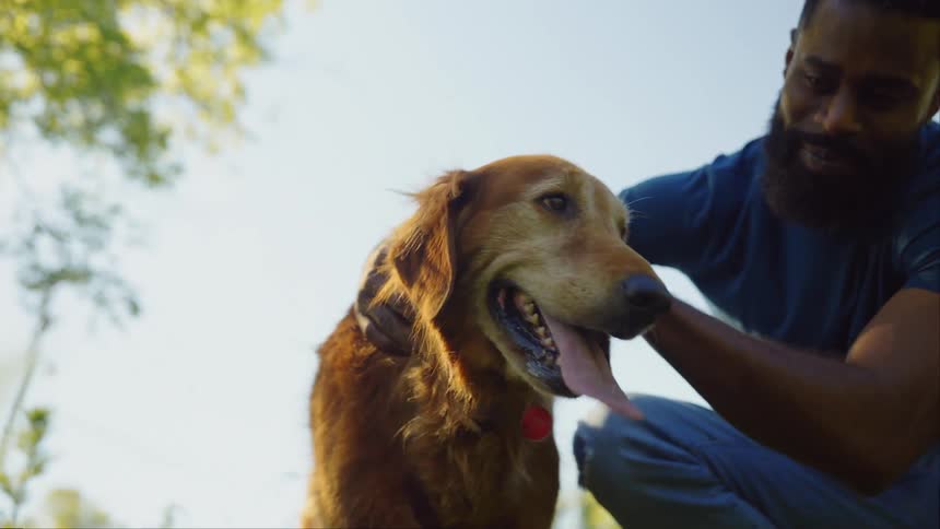 A man is petting his dog