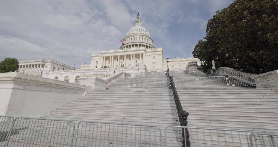 A wide staircase leading up to the united states capitol building with a clear sky above