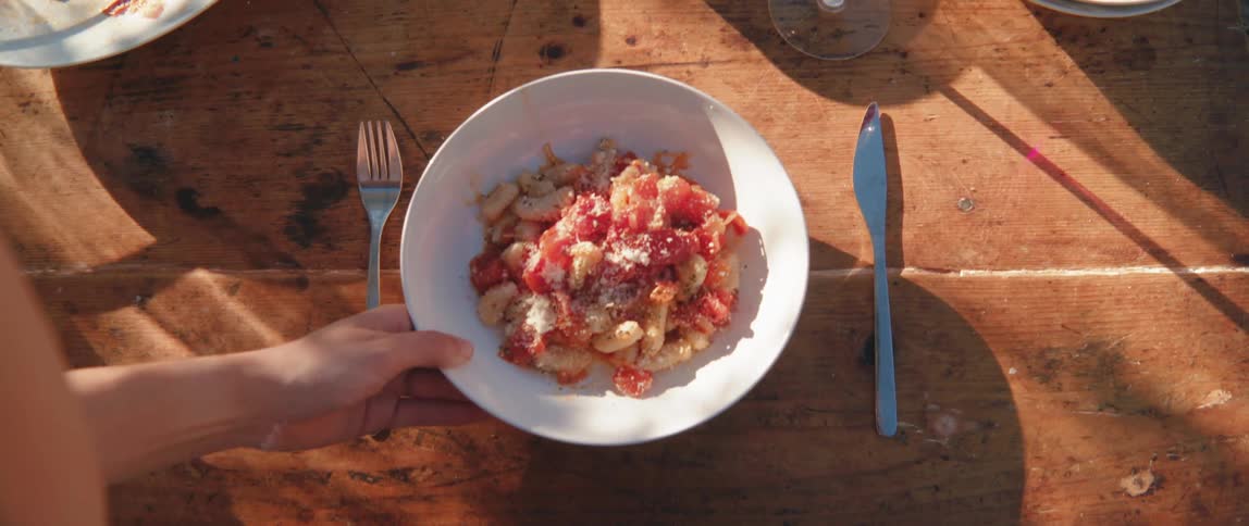 A person sets a bowl of food on a table