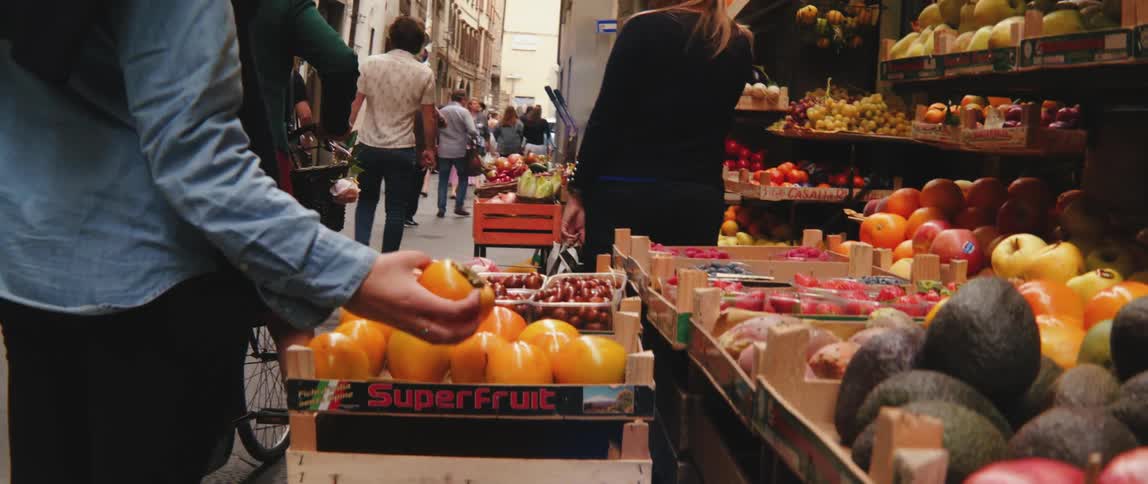 A person selecting fruit in a street market