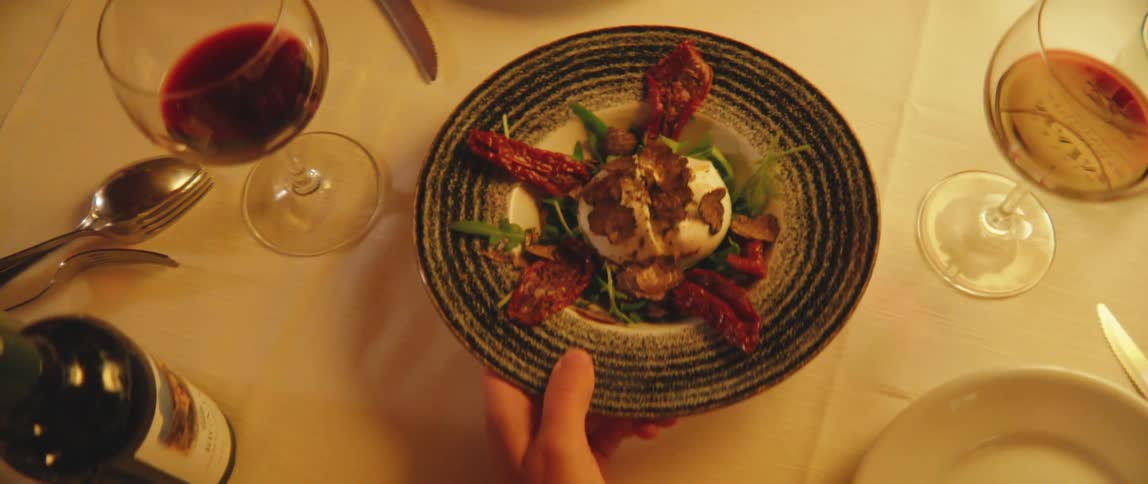 A restaurant employee sets a plate of food on a table