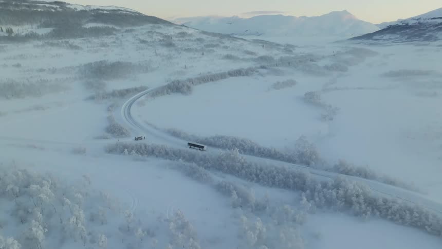 A bus driving across a snow covered landscape