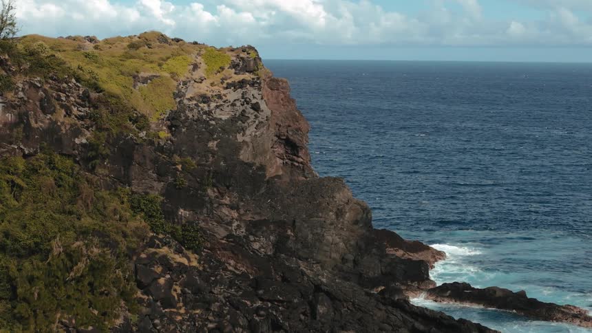 Waves hit a mountainous coastal area