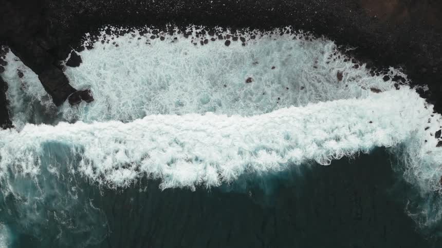 The tide rolls into a beach