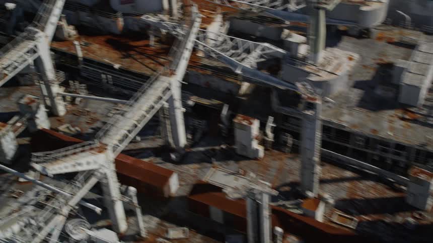 Aerial view of three cargo ships in poor condition covered in rust