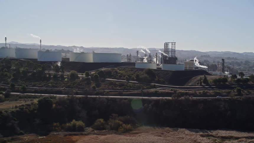Pollution rises from the factory on the hill