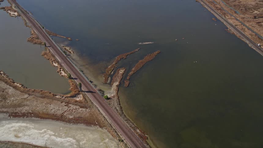 An aerial clip of a lake beside a bridge