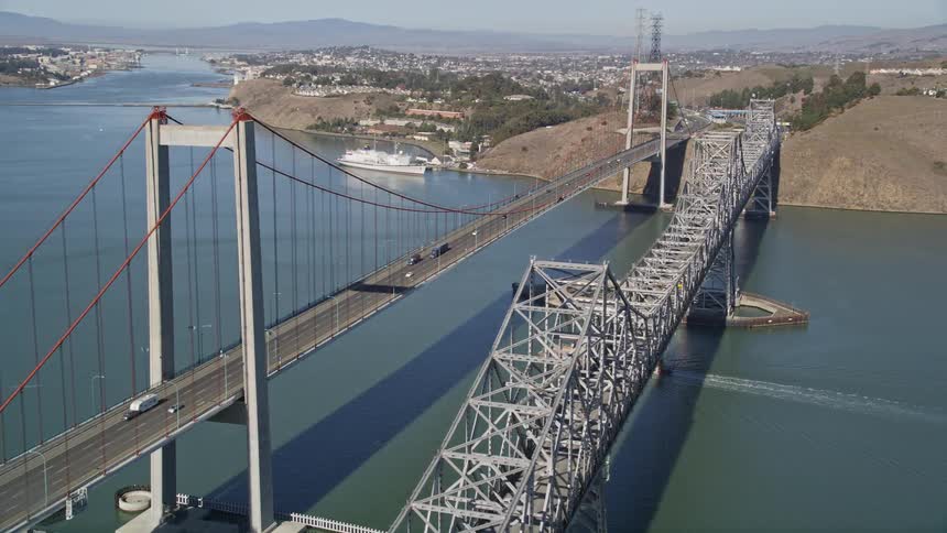 Aerial panorama of two bridges under the sea with vehicle traffic connecting urban cities in mountainous locations